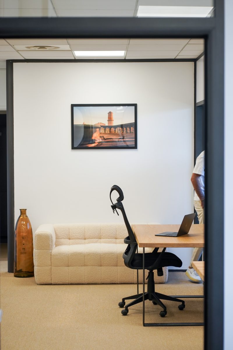 Bureau du cabinet vu depuis l'entrée : canapé, bureau en bois et fauteuil